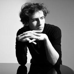 Een zwart-wit foto van pianist Alexander Kantorow