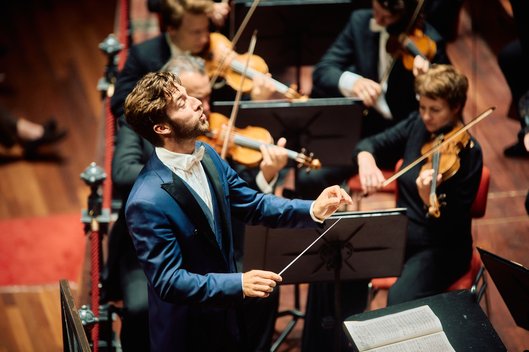 Actiefoto van dirigent Lorenzo Viotti tijdens een concert.